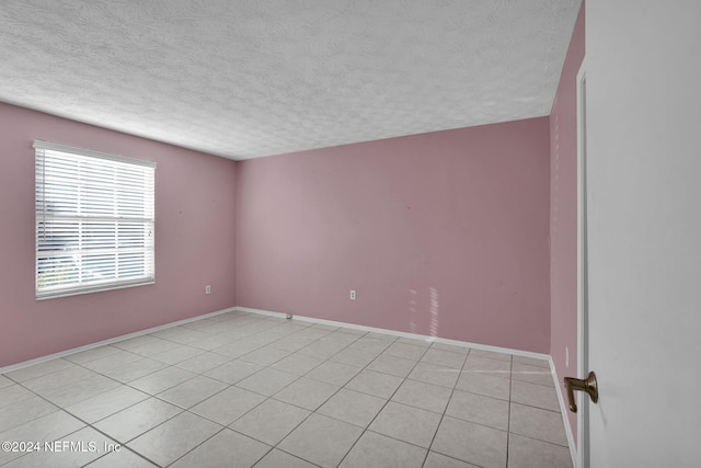 tiled spare room with a textured ceiling