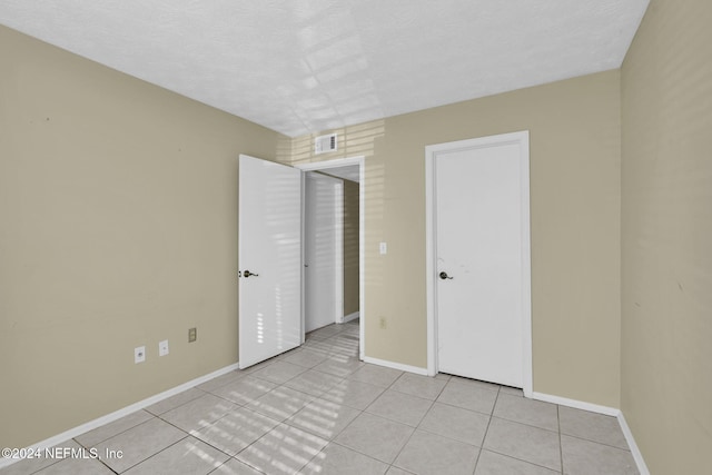 unfurnished bedroom with light tile patterned floors and a textured ceiling