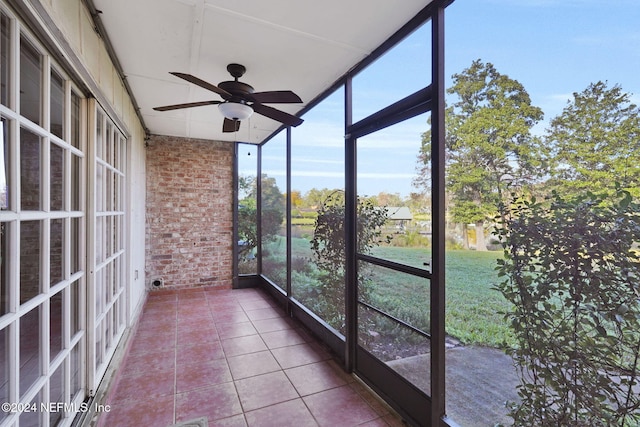 unfurnished sunroom with ceiling fan