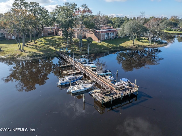 view of dock with a yard and a water view