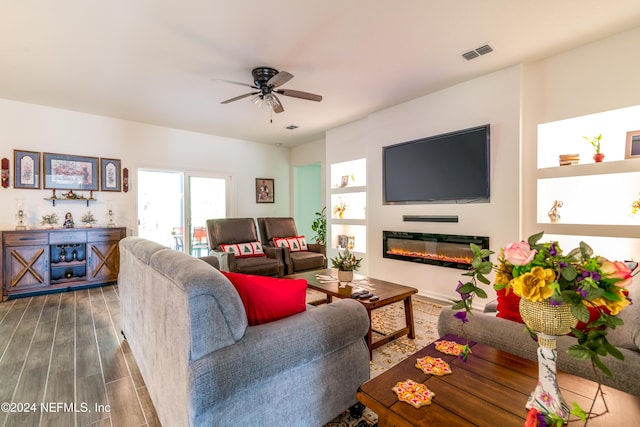 living room with ceiling fan and dark wood-type flooring