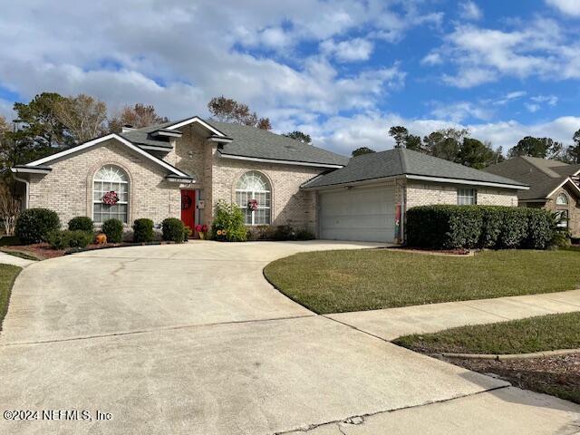 1837 The Glades Rd, Middleburg, FL 32068 - view of front of property with driveway, brick siding, a front yard, and a garage