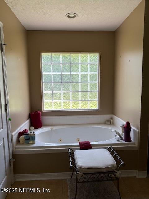 1837 The Glades Rd, Middleburg, FL 32068 - full bathroom featuring plenty of natural light, a whirlpool tub, tile patterned floors, and a textured ceiling