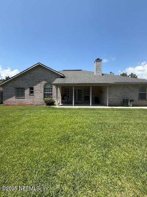 1837 The Glades Rd, Middleburg, FL 32068 - rear view of property with a chimney, a yard, brick siding, and a patio