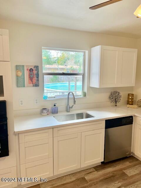 kitchen featuring white cabinetry, dishwasher, ceiling fan, sink, and hardwood / wood-style flooring