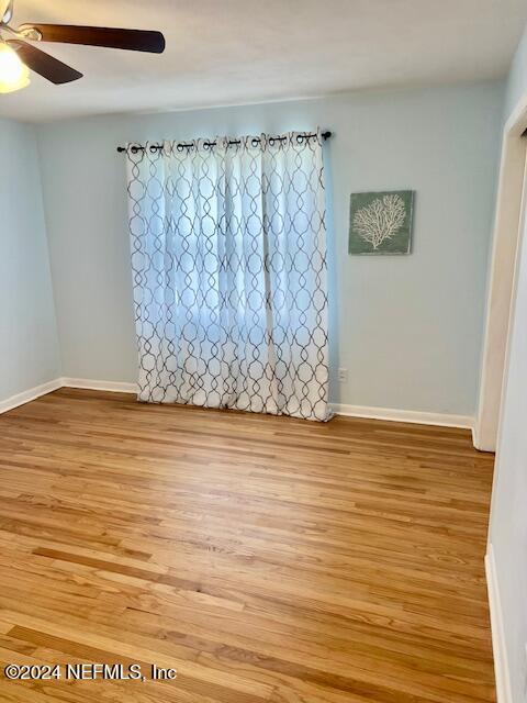 empty room with ceiling fan and light hardwood / wood-style floors