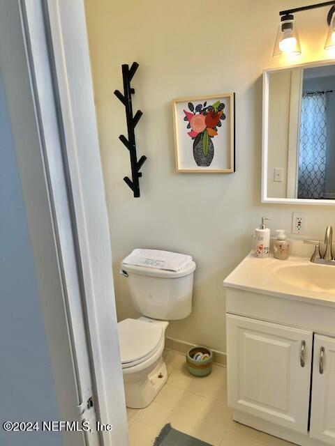 bathroom featuring toilet, vanity, and tile patterned floors