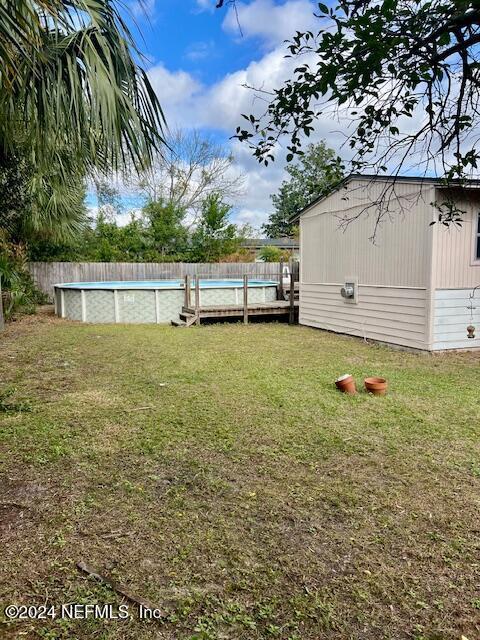 view of yard with a fenced in pool and a shed