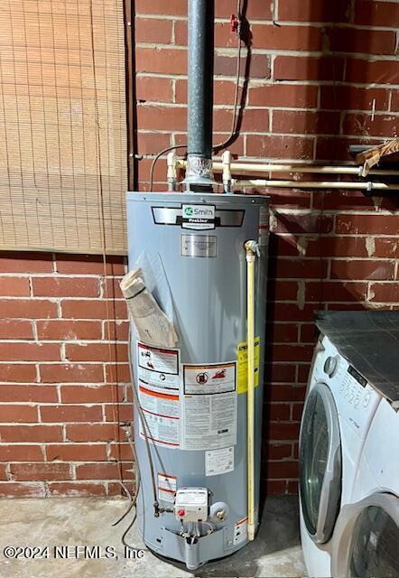 utility room with water heater and washer / dryer