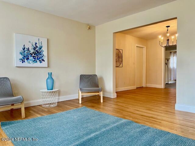 unfurnished room with a chandelier and hardwood / wood-style flooring