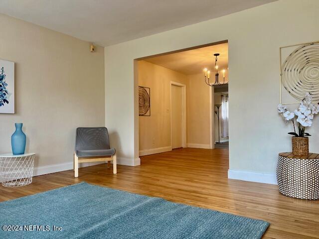 living area with hardwood / wood-style floors and an inviting chandelier