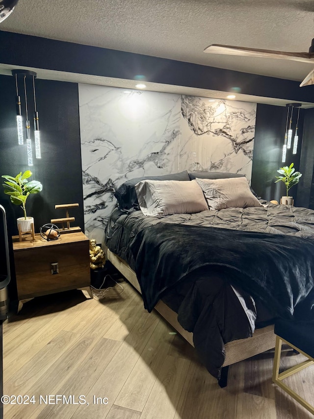 bedroom with a textured ceiling and hardwood / wood-style flooring