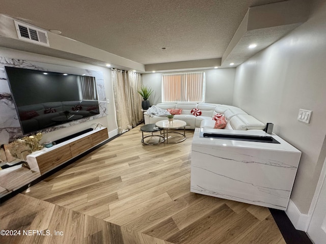 living room with wood-type flooring and a textured ceiling