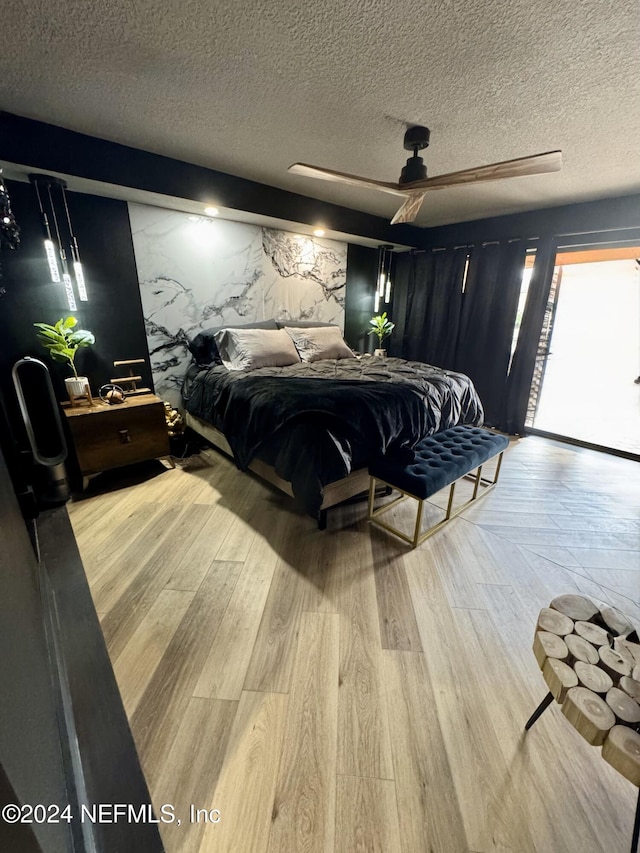 bedroom featuring a textured ceiling, light hardwood / wood-style flooring, and ceiling fan