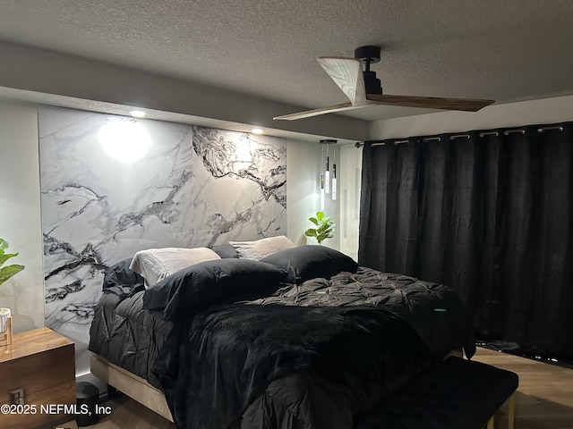 bedroom featuring a textured ceiling, ceiling fan, and wood finished floors