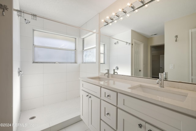 bathroom featuring a tile shower and vanity