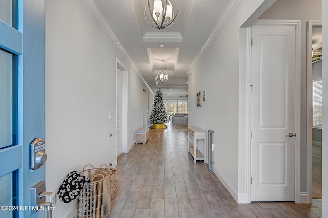 corridor featuring ornamental molding, light hardwood / wood-style flooring, and a notable chandelier