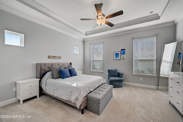 bedroom featuring ceiling fan, a raised ceiling, ornamental molding, and light carpet