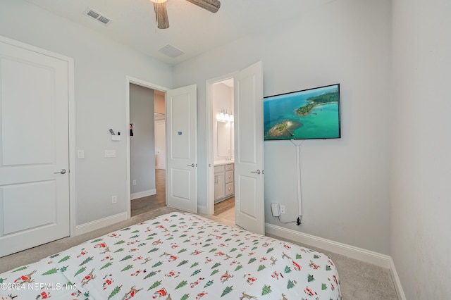 bedroom featuring ceiling fan, light carpet, and connected bathroom