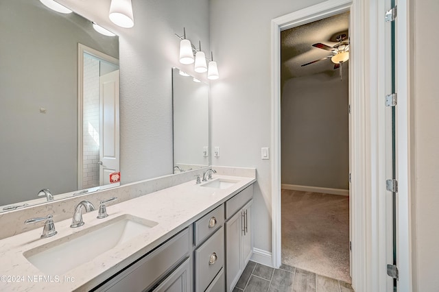 bathroom featuring ceiling fan, vanity, and a textured ceiling