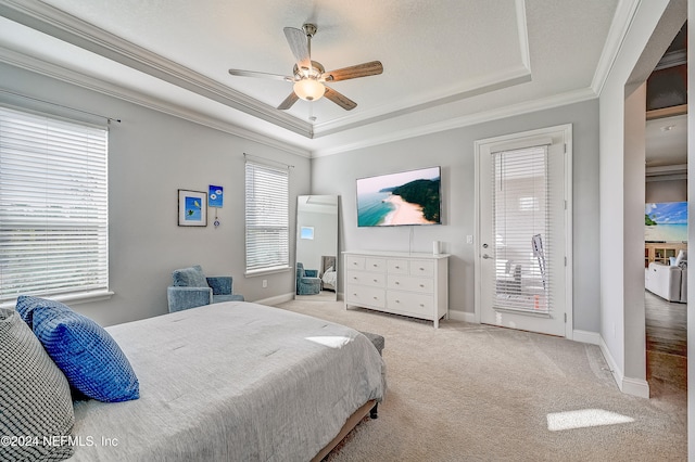 carpeted bedroom with a tray ceiling, access to exterior, ceiling fan, and crown molding