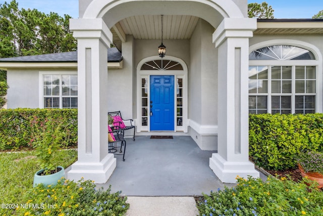 view of exterior entry featuring covered porch