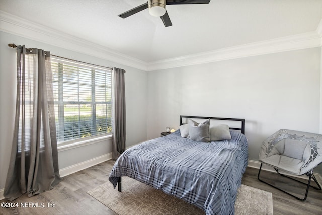 bedroom featuring ceiling fan, crown molding, and hardwood / wood-style flooring