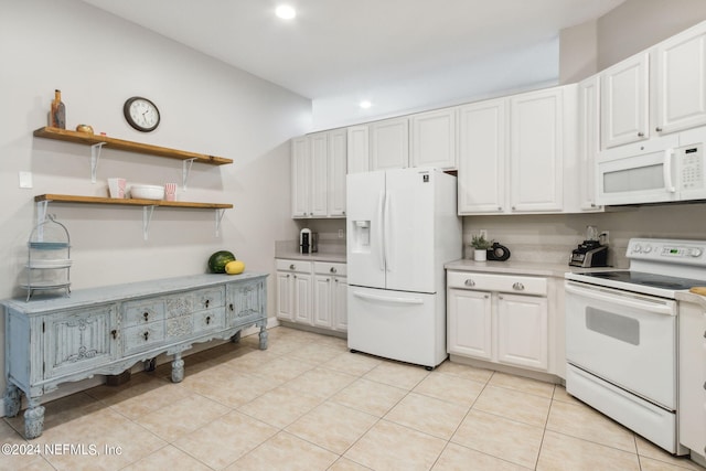 kitchen featuring light tile patterned floors, white cabinets, and white appliances