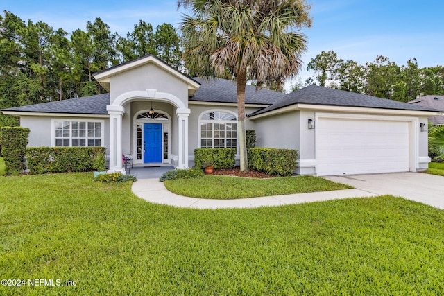 ranch-style home featuring a garage and a front lawn