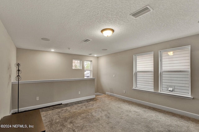 empty room featuring carpet floors and a textured ceiling