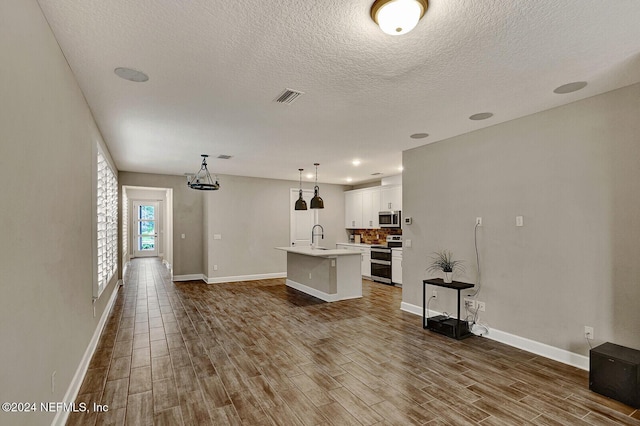 unfurnished living room with a textured ceiling, hardwood / wood-style flooring, and sink