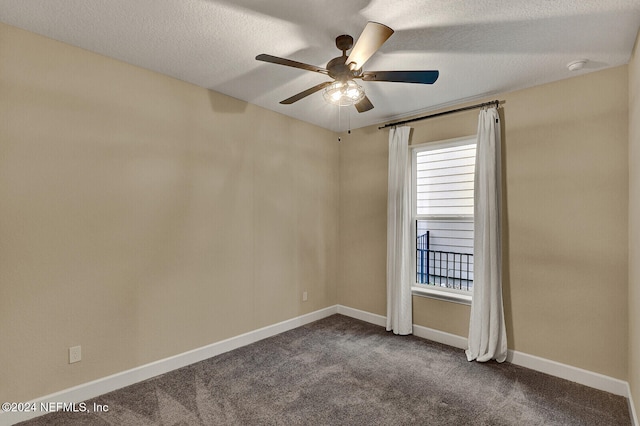 empty room with ceiling fan, dark carpet, and a textured ceiling