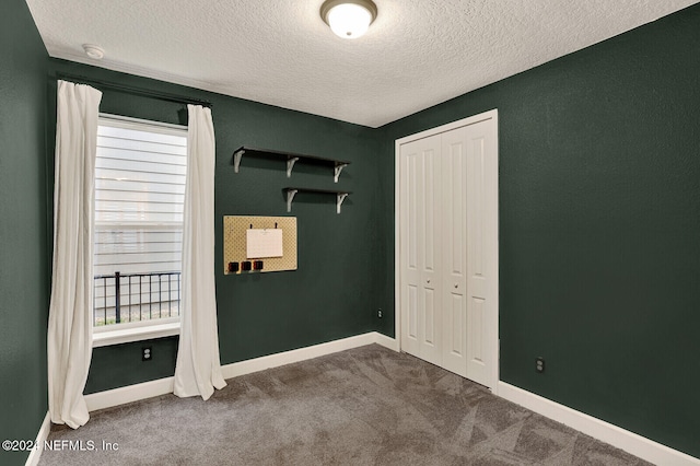 unfurnished bedroom with a textured ceiling, carpet floors, and a closet