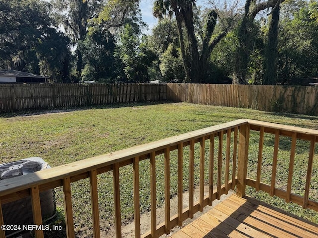 wooden terrace featuring central air condition unit and a lawn