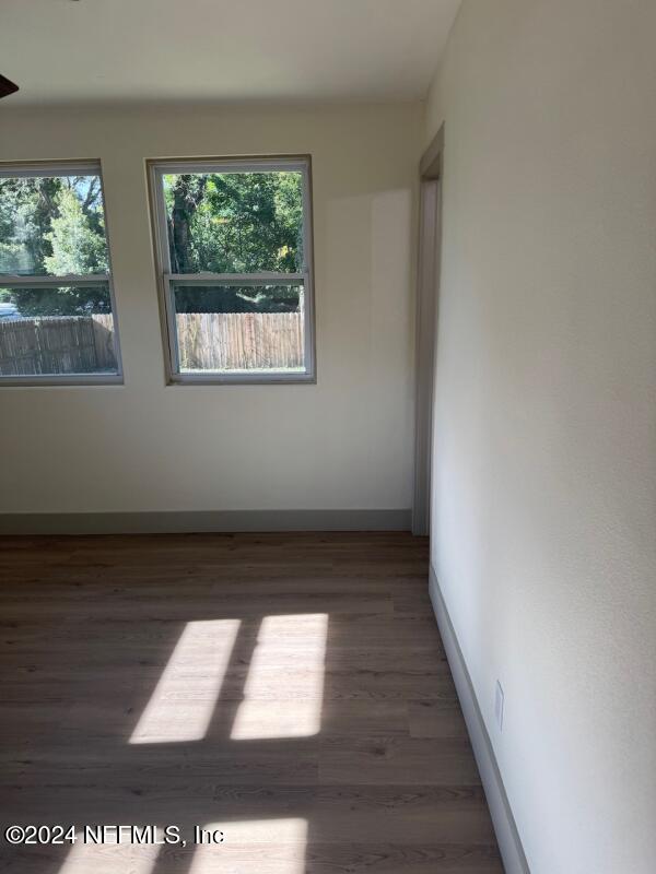 unfurnished room with dark hardwood / wood-style flooring