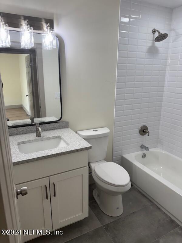 full bathroom with tile patterned floors, vanity, toilet, and tiled shower / bath