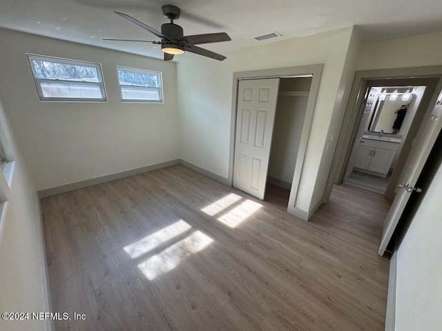 unfurnished bedroom featuring ceiling fan, light hardwood / wood-style floors, and a closet