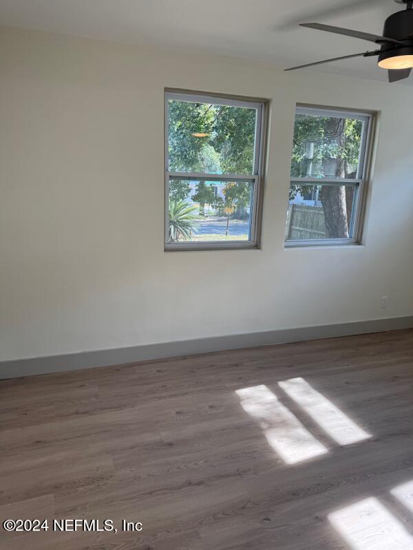 spare room featuring hardwood / wood-style flooring, a wealth of natural light, and ceiling fan