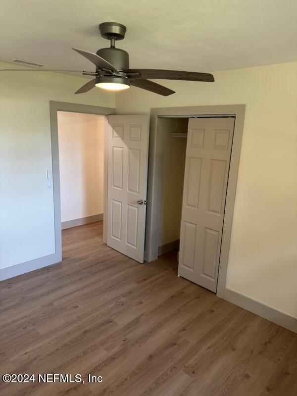 unfurnished bedroom with a closet, ceiling fan, and hardwood / wood-style floors