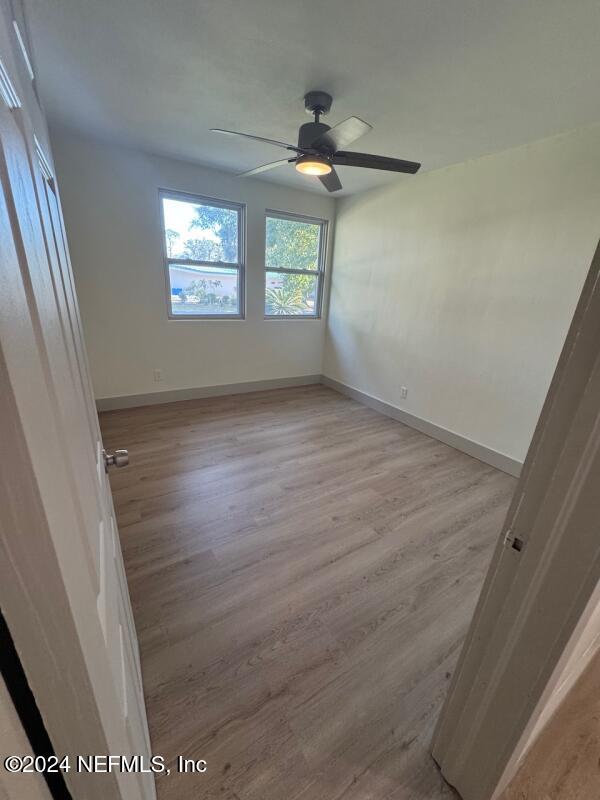 spare room featuring ceiling fan and light hardwood / wood-style flooring