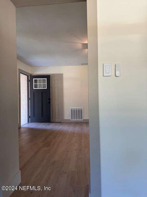 corridor with dark hardwood / wood-style flooring