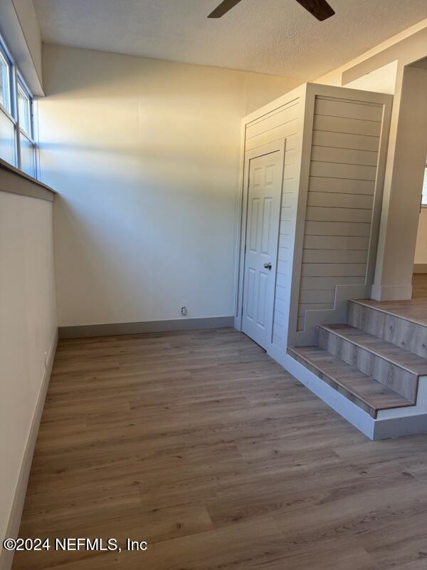 interior space with a textured ceiling and light hardwood / wood-style flooring