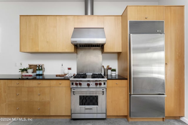 kitchen featuring light brown cabinets, high quality appliances, and wall chimney range hood