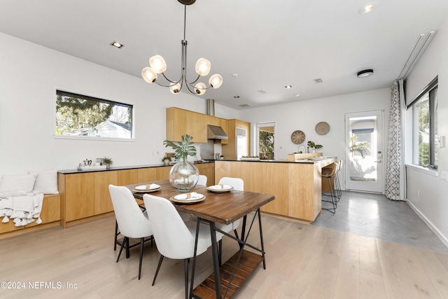 dining room with light hardwood / wood-style floors and an inviting chandelier