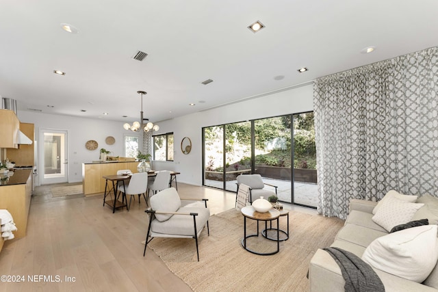 living room featuring light hardwood / wood-style flooring and an inviting chandelier