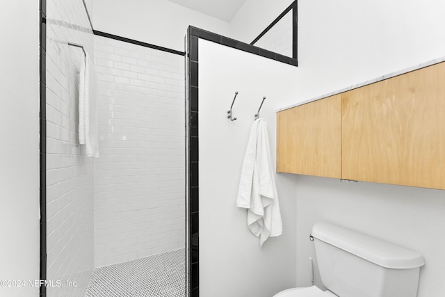 bathroom with toilet and tiled shower