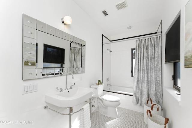 bathroom with tile patterned floors, toilet, and shower / bathtub combination with curtain