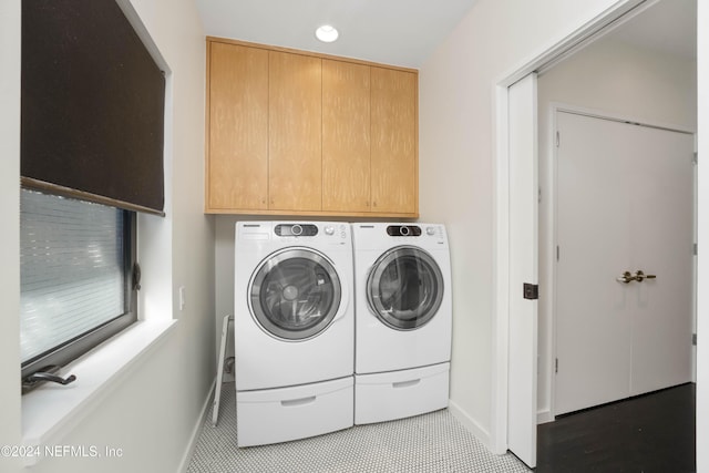 clothes washing area with cabinets, light tile patterned floors, and washer and clothes dryer