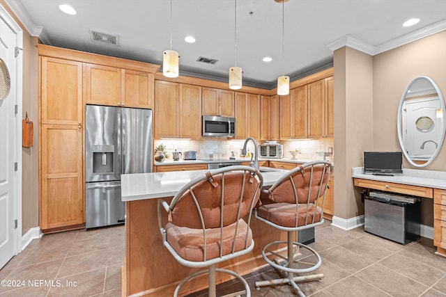 kitchen featuring a kitchen island with sink, light tile patterned floors, appliances with stainless steel finishes, decorative light fixtures, and a kitchen bar