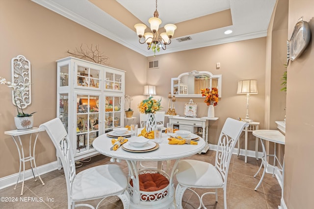 dining room with light tile patterned floors, an inviting chandelier, a raised ceiling, and crown molding